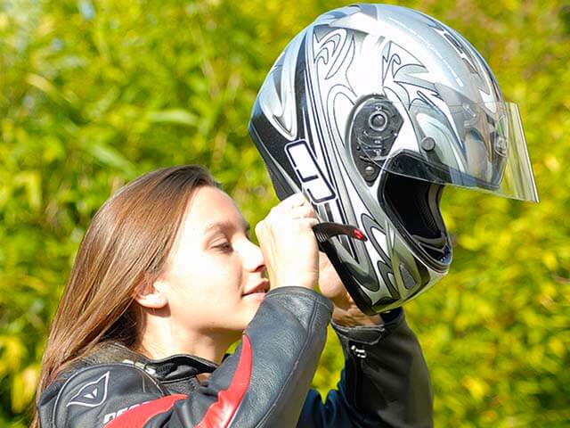 Jeune motarde enfilant un casque VIALEARN Moto